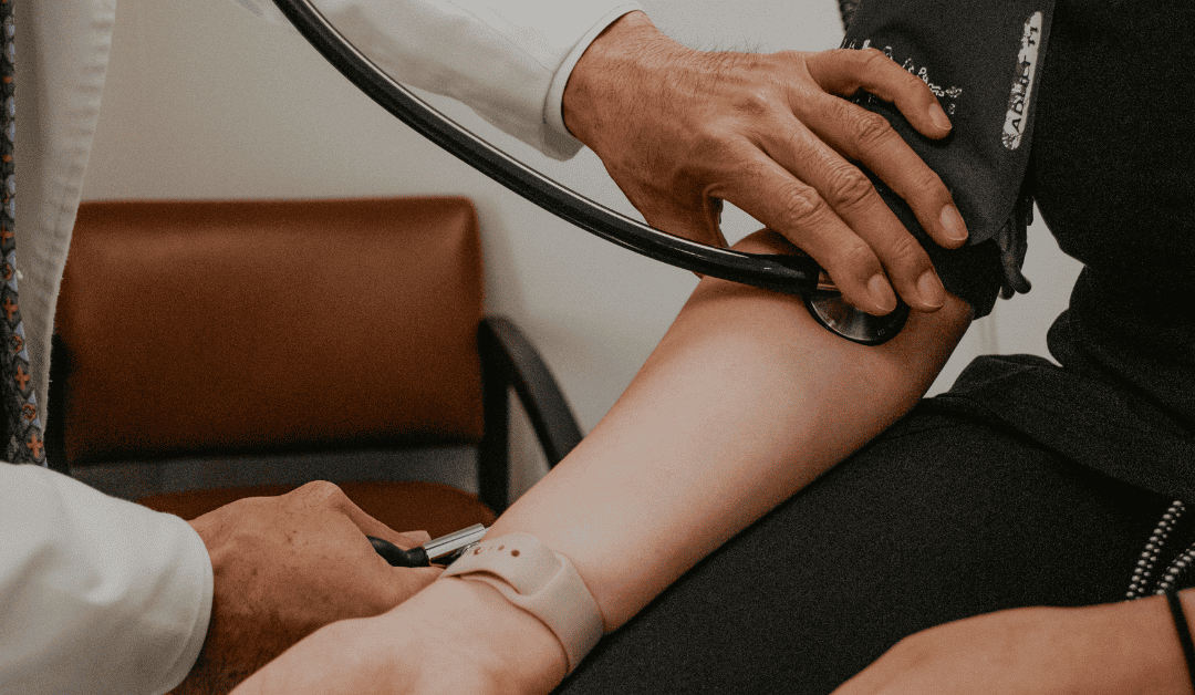 a doctor taking the blood pressure of a patient